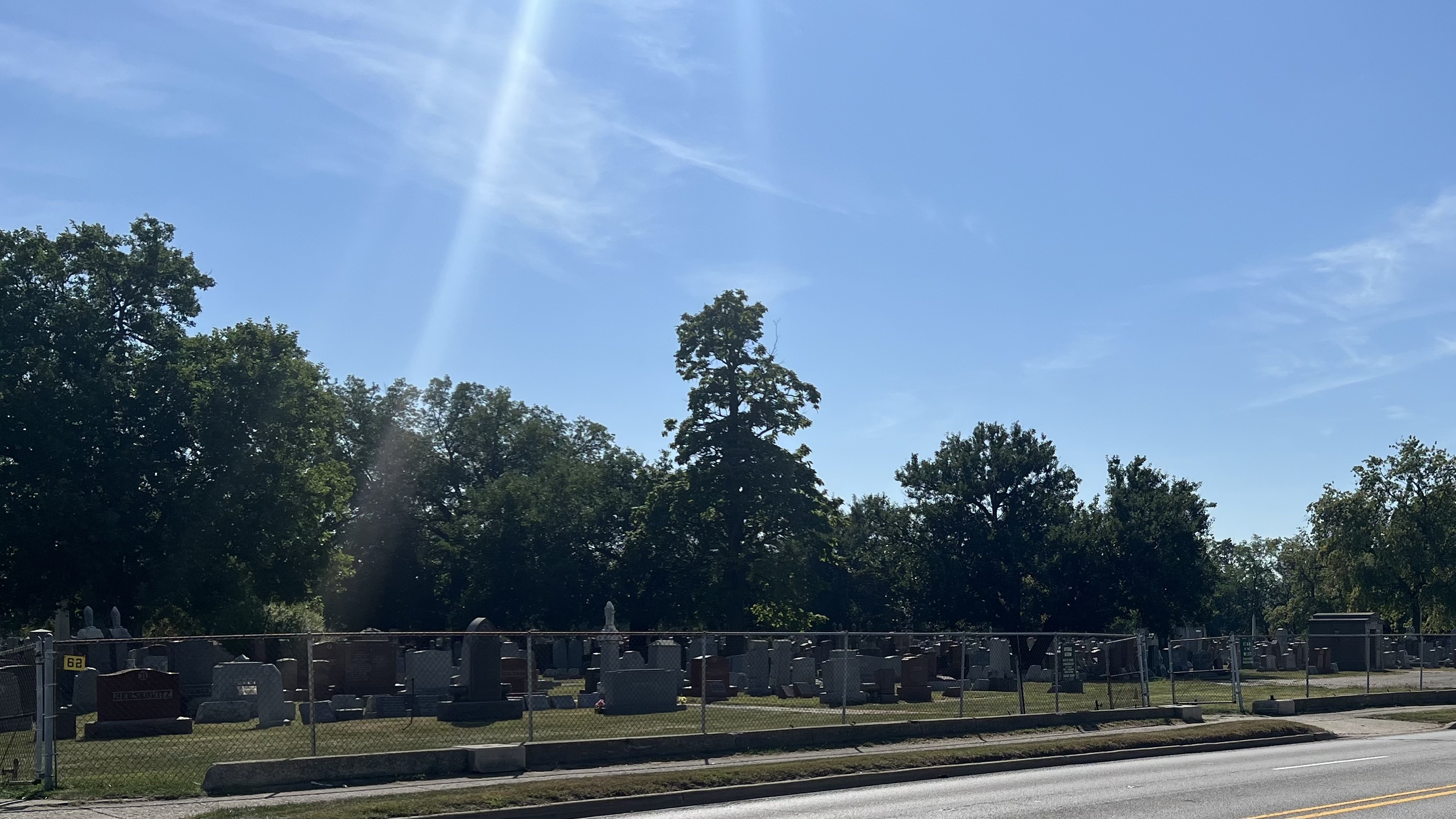 a picture of a cemetery along a sidewalk