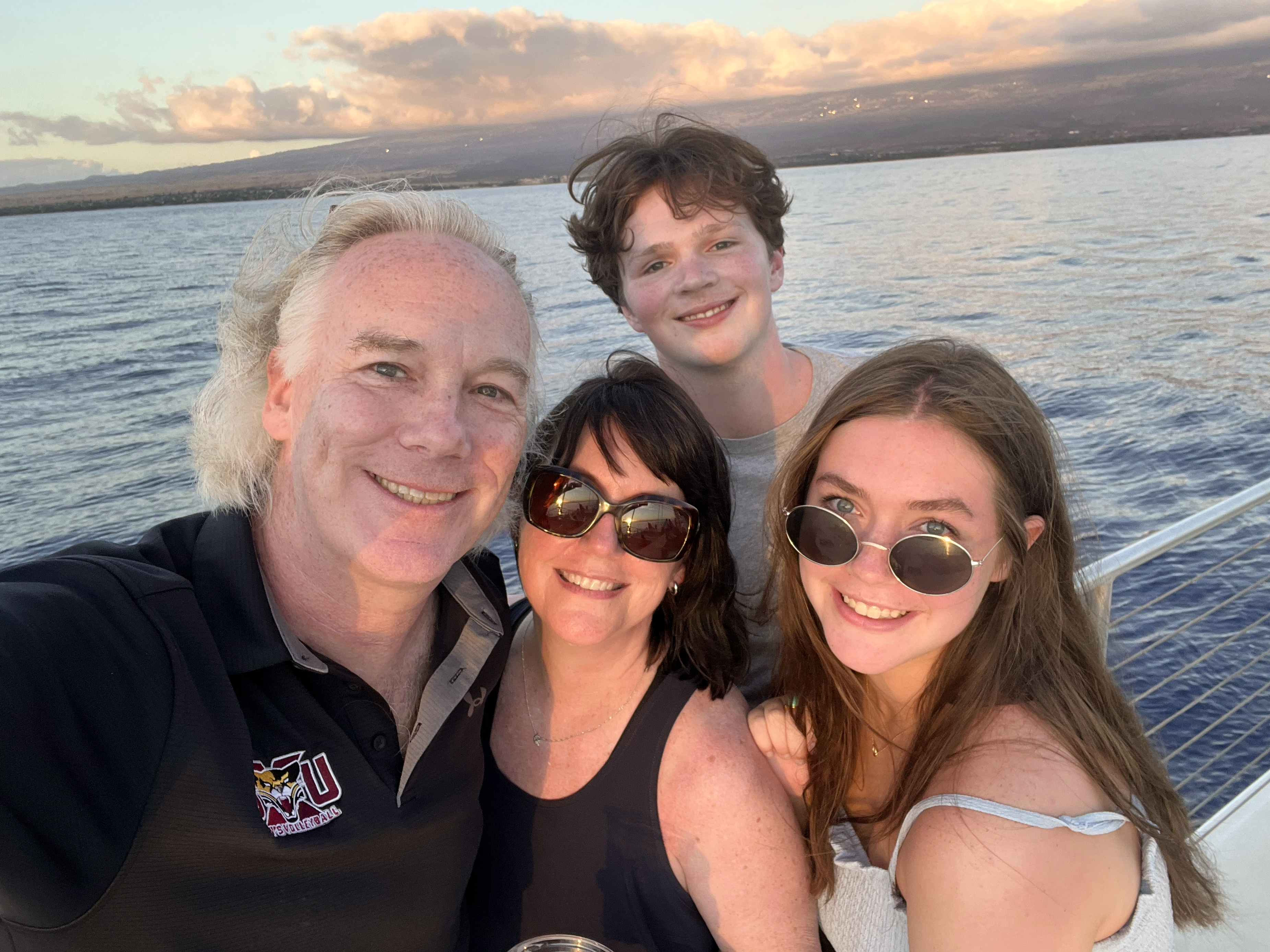 family portrait in the sunset from the deck of a boat