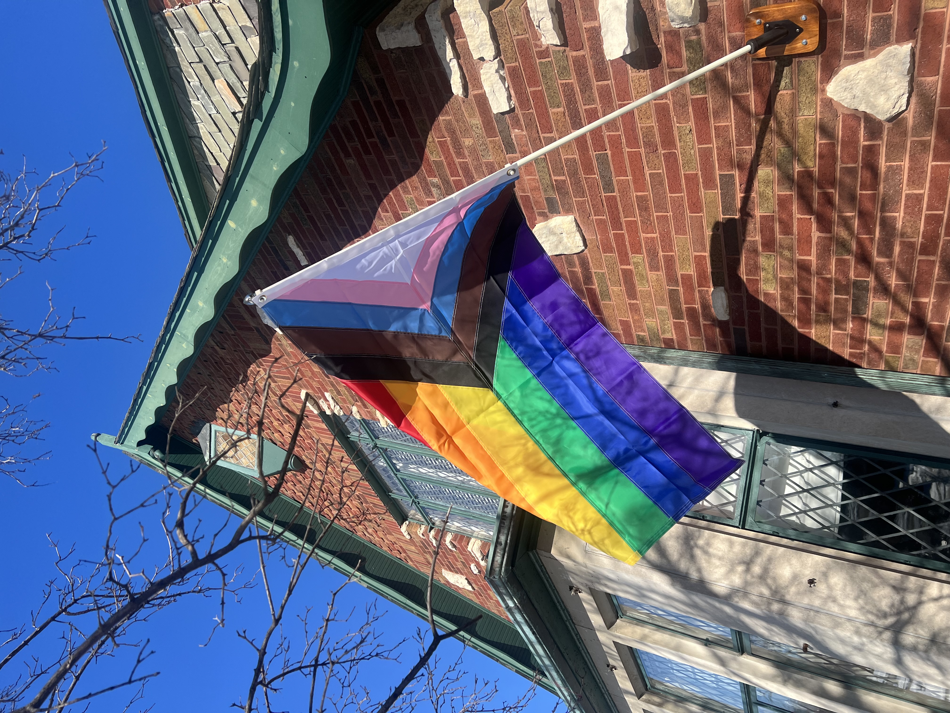 the progress pride flag on display in front of my house