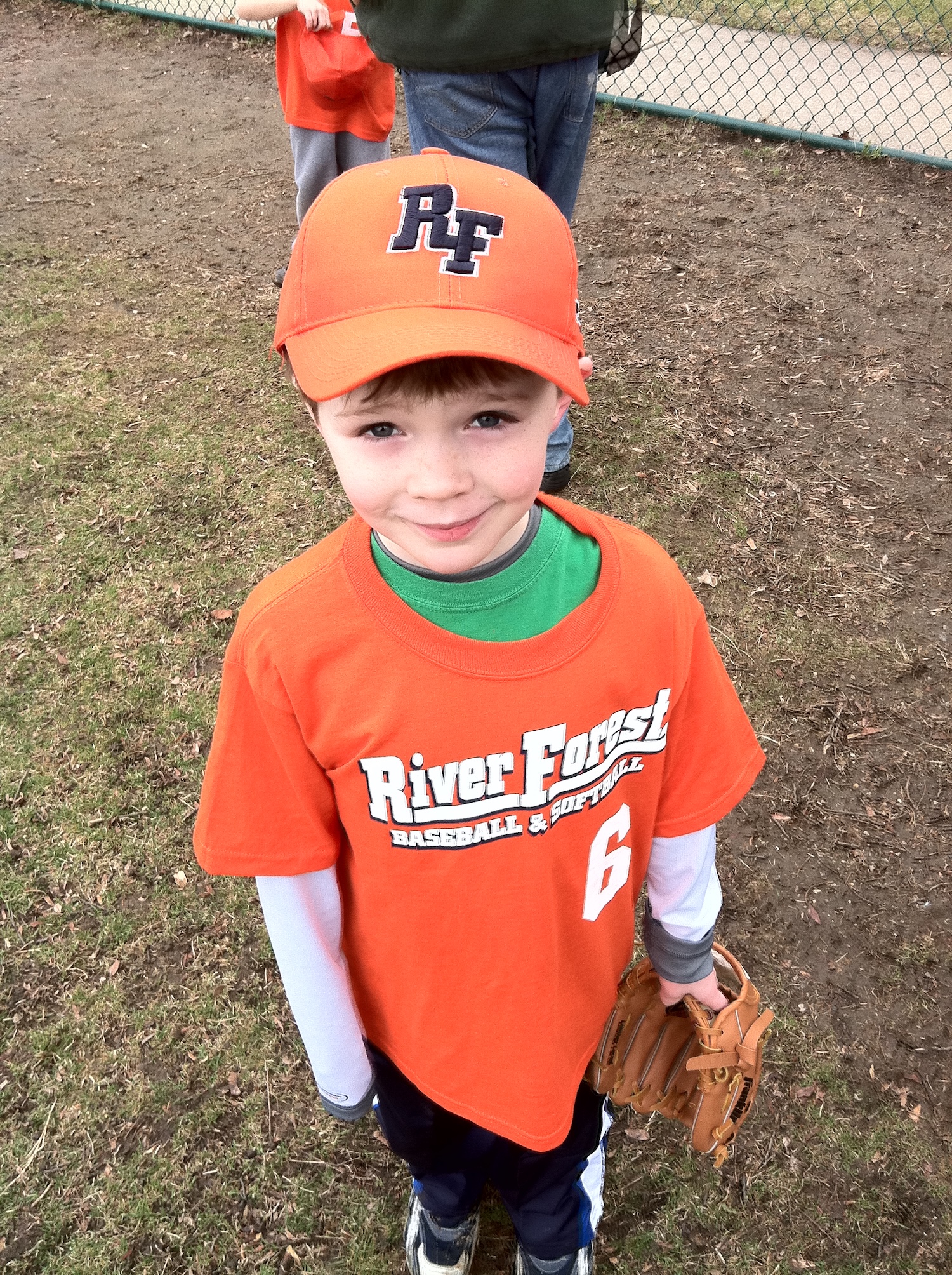 Danny at seven years old in an orange River Forest Baseball uniform